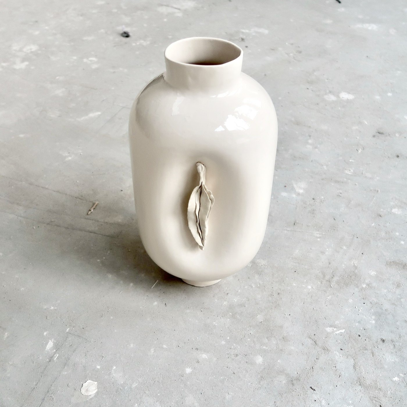 White ceramic Vulvase on a concrete floor